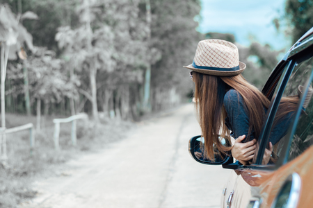 Happy young woman looking out of car window,Toward adventure,relaxing and enjoying road trip.の写真素材