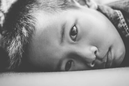 Portrait of a child with a sad face on sofa.の写真素材