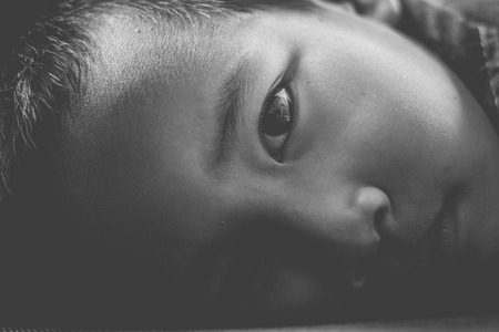 Portrait of a child with a sad face on sofa.Black and white tone.の写真素材