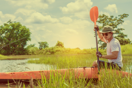 Young man on boat fishing during in The River. Man Relaxing During Vacation.の写真素材