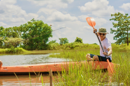 Young man on boat fishing during in The River. Man Relaxing During Vacation.の写真素材