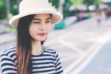 Close up shot of stylish young woman in hat against  street background. Beautiful female model.の写真素材