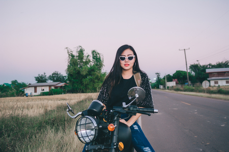Young sexy woman on a motorcycle in nature on the sunset.Travel Concept.の写真素材
