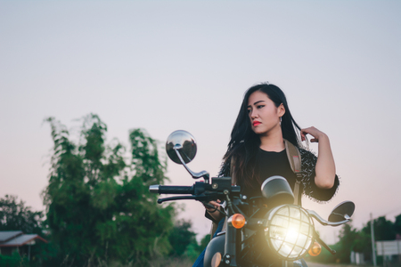 Young sexy woman on a motorcycle in nature on the sunset.Travel Concept.の写真素材