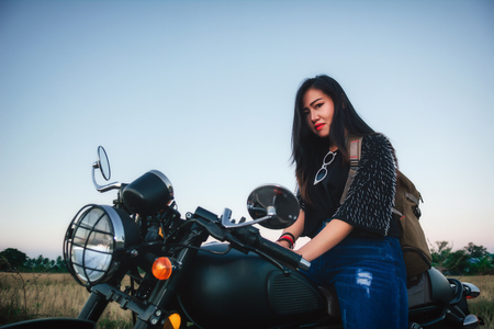 Young woman drive with motorbike on street, enjoying freedom and active lifestyle, having fun on a bikers tour.の写真素材