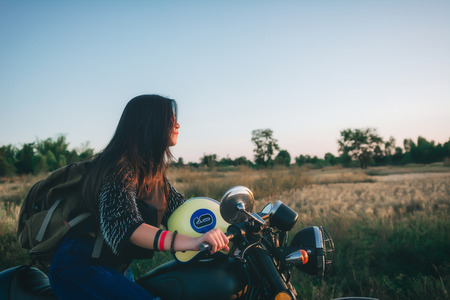 Young woman drive with motorbike on street, enjoying freedom and active lifestyle, having fun on a bikers tour.の写真素材