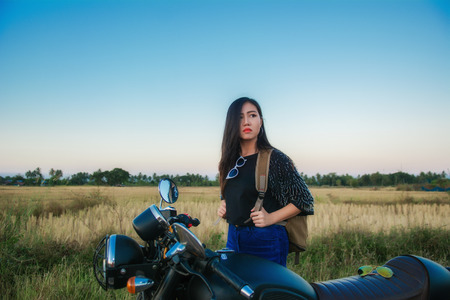 Young woman drive with motorbike on street, enjoying freedom and active lifestyle, having fun on a bikers tour.の写真素材