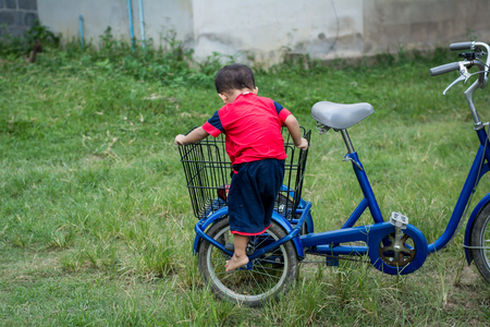 Happy children playing with a bike alone.の写真素材