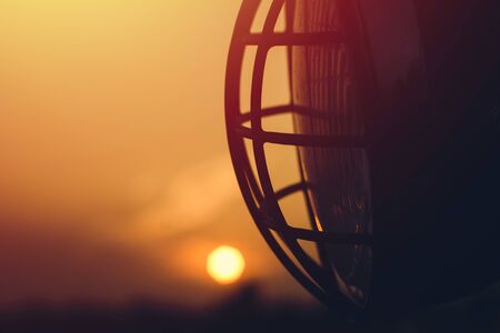 Close-up of motorcycle headlight on sunset background.の写真素材