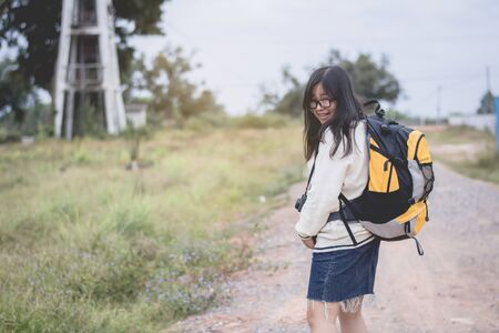 Asian women traveling alone with backpack and camera.Travel Holiday Relaxation Concept , Vintage...