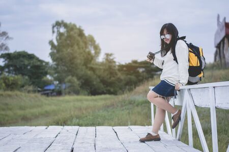 Asian women traveling alone with backpack and camera.Travel Holiday Relaxation Concept , Vintage...