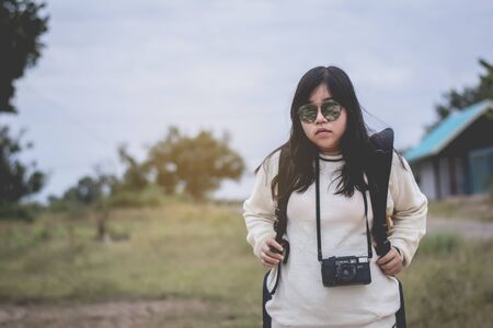 Asian women traveling alone with backpack and camera.Travel Holiday Relaxation Concept , Vintage Style.の写真素材