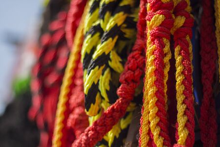 yellow black nylon rope hanged along with red rope for sale at cattle market