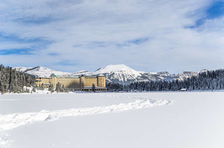 Frozen and covered in snow Lake Louise, the hotel and Rocky Mountains in Banff National Park Alberta, Canadaの写真素材