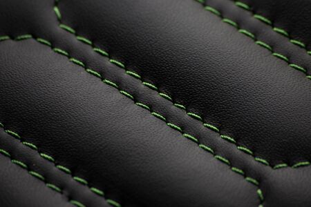 Embroidery on a car seat on black leather with green threadsの写真素材