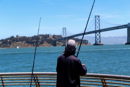Fisherman with fishing rods near the White Bridge between San Francisco and Auckland in California