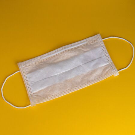 protective medical mask on a yellow background