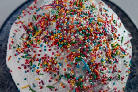 Easter cake close-up: white icing and colored sweet decorationsの写真素材
