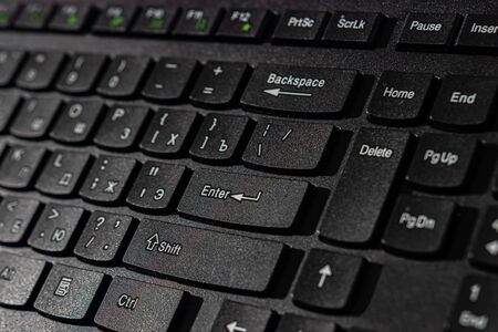 black keyboard with white russian and english letters with hard lightの写真素材