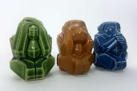 Model of a ceramic monkey with ears closed eyes closed on white backgroundの写真素材