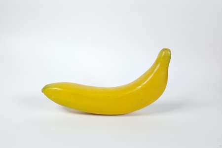 Plastic toy banana And a white backdropの写真素材