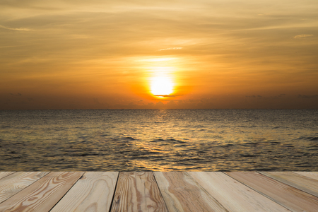A golden sky landscape, sunrise in the sea with a wooden space.の写真素材