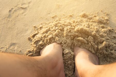 Picture of a foot buried in the sand at the beach.の写真素材