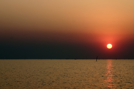 Sunset in the ocean with golden skyの写真素材