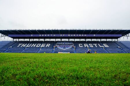 Navy blue amphitheater in football arena with green football pitchの写真素材