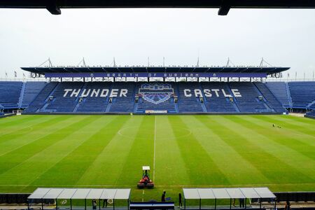 Navy blue amphitheater in football arena with green football pitchの写真素材