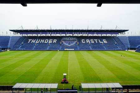 Navy blue amphitheater in football arena with green football pitch