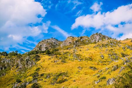 mountain hill with rocks  grasses and  clear blue sky backgroundの写真素材