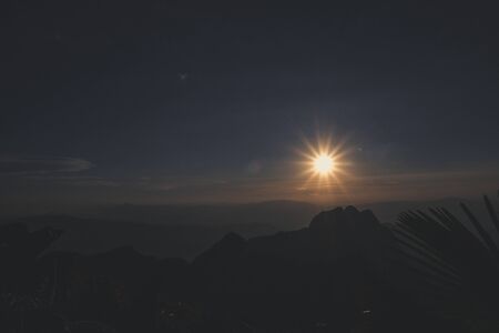 sunrise sky backlit with big mountainの写真素材