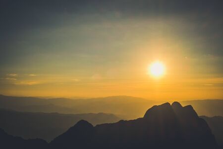 sunrise sky backlit with big mountainの写真素材