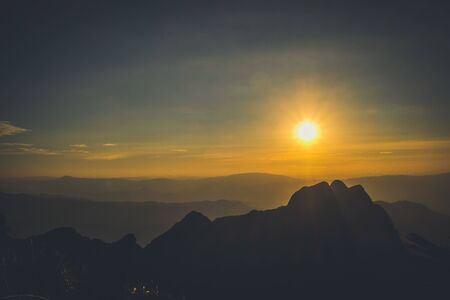 sunrise sky backlit with big mountainの写真素材