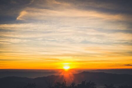 sunrise backlit sky with cloud on the top of mountainの写真素材