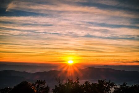 sunrise backlit sky with cloud on the top of mountainの写真素材