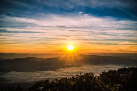 sunrise backlit sky with cloud on the top of mountainの写真素材