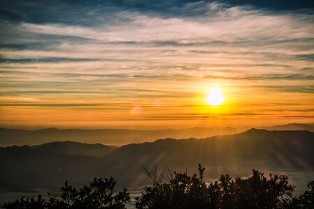 sunrise backlit sky with cloud on the top of mountainの写真素材