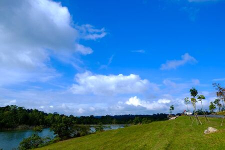 green field with lake and sky backgroundの写真素材