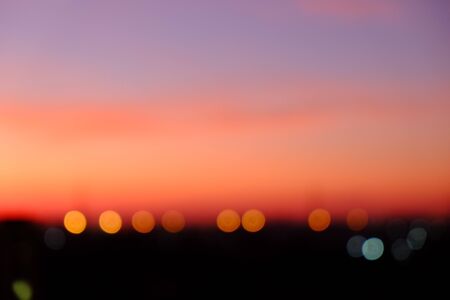 sunset sky shading background from orange to blue with bokehの写真素材