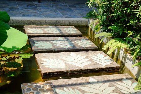 little pond with walkway in front of the houseの写真素材