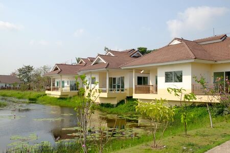 house near the pond with clear blue skyの写真素材