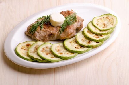Pork steak, grilled, with melting butter and vegetablesの写真素材