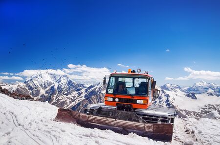 Snow machines in the Caucasus Mountains clear sunny day with birds flying in the skyの写真素材