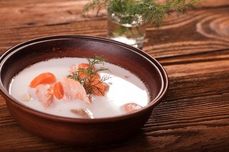 Fish soup with salmon, cream, vegetables and herbsの写真素材