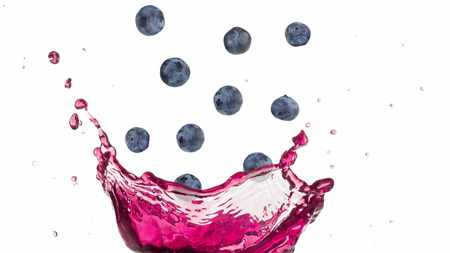 blueberries falling into a splashing purple juiceの写真素材