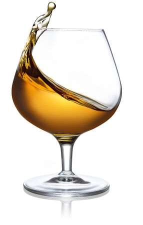 splash of cognac in a snifter isolated on white backgroundの写真素材