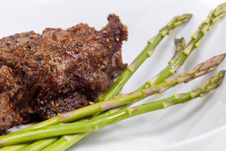A prime Fillet Mignon grilled to perfection "au poive" with peppercorns and garnished with fresh asparagus.  の写真素材
