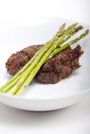 A prime Fillet Mignon grilled to perfection "au poive" with peppercorns and garnished with fresh asparagus.  の写真素材